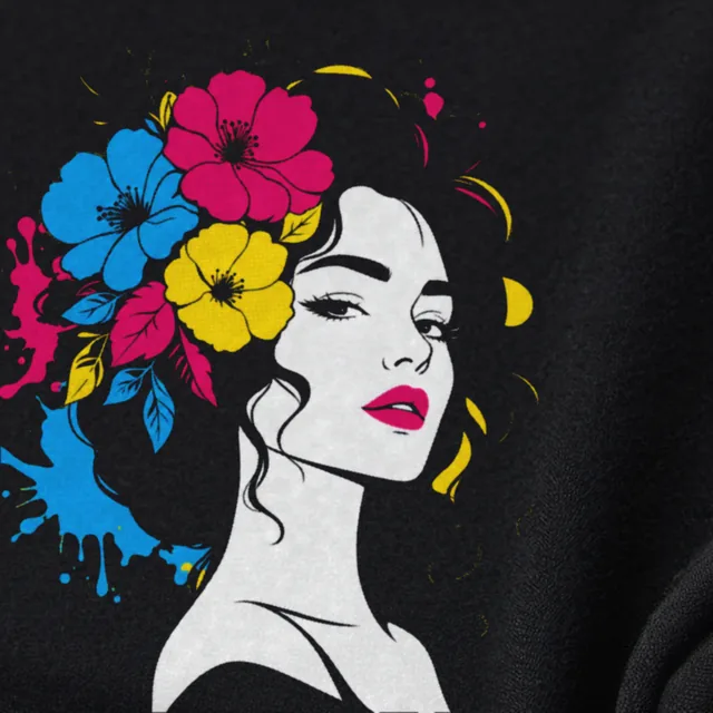 Close-up of a black T-shirt printed with a woman with flowers in her hair, in fine halftone dots of pink, blue, yellow and white.